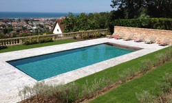 Piscine de 12 x 6 m carrelée et plage en pavés gris sur les hauteurs de Deauville