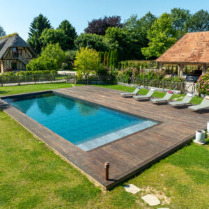 Piscine familiale de 13x5 avec un escalier toute largeur et margelles en bois - Réalisation Delalande Piscines & Spas