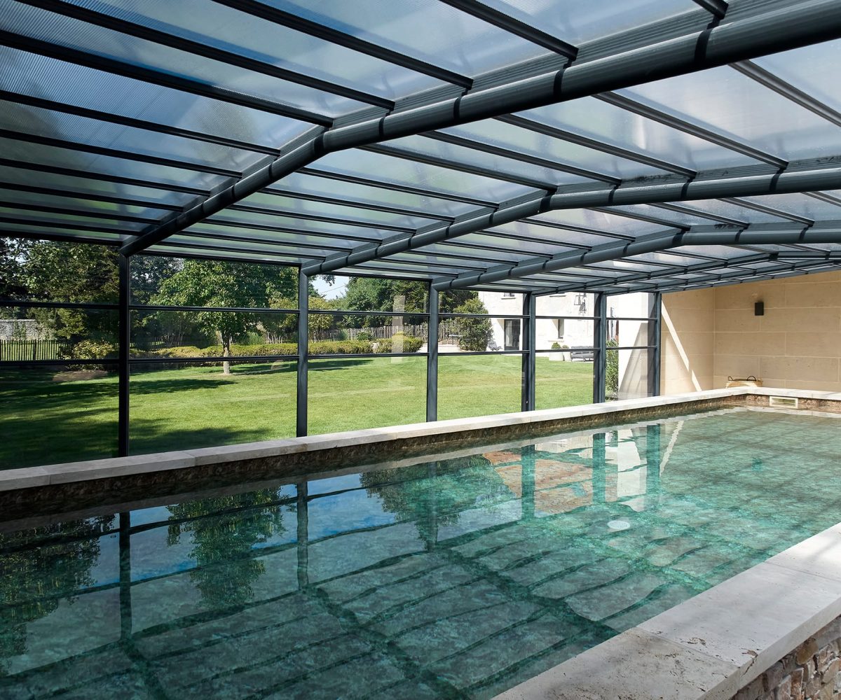 Piscine avec margelles et plages en pierre naturelle travertin beige.