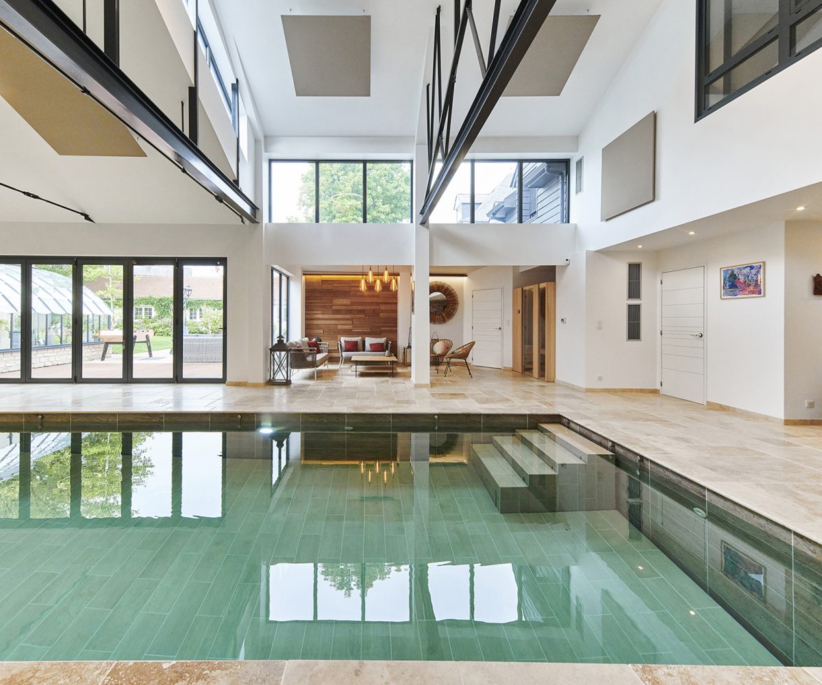 Piscine intérieure 12 x 4 m avec revêtement en carrelage.