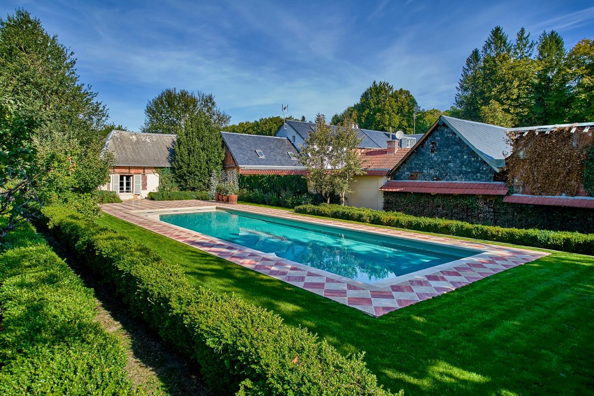 Couloir de nage entourée d’une terrasse en travertin rose et nuancé.