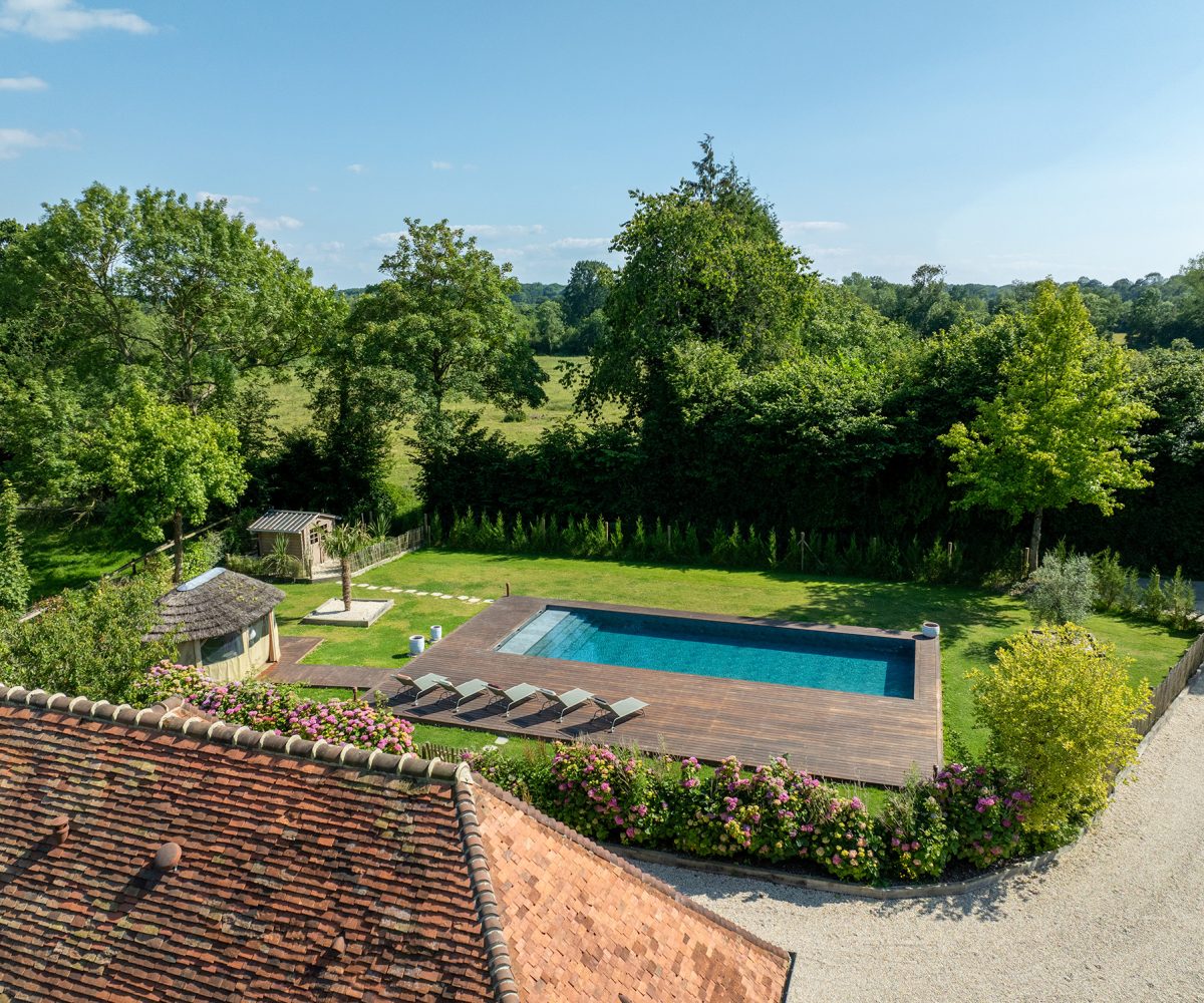 Vue aérienne d’une piscine classique avec terrasse en bois et volet immergé discret