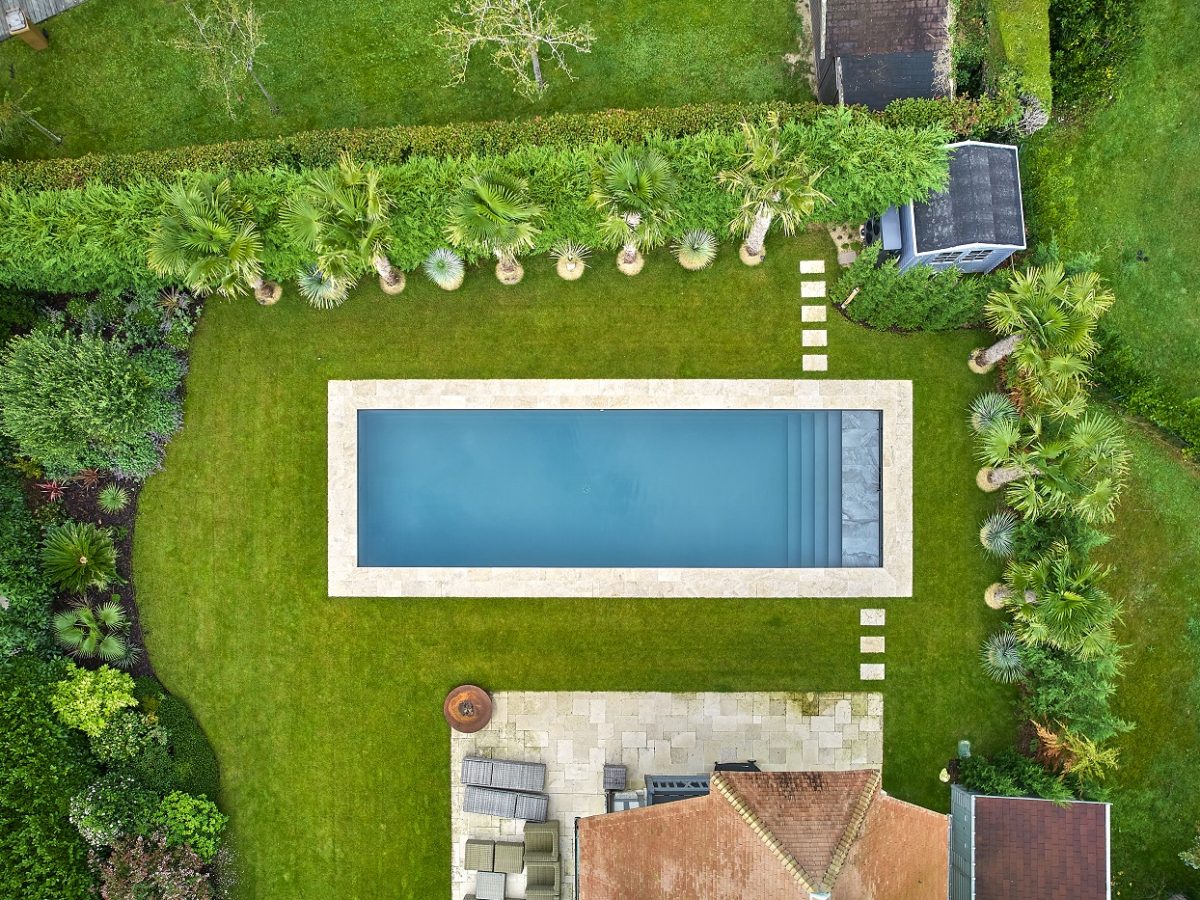 Piscine extérieure rectangulaire dans jardin végétalisé