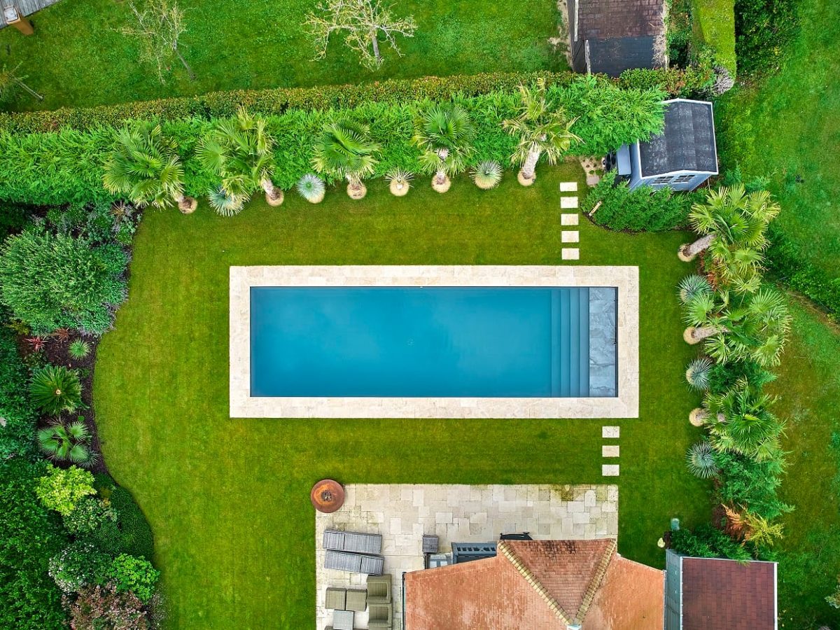 Piscine extérieure rectangulaire dans jardin végétalisé