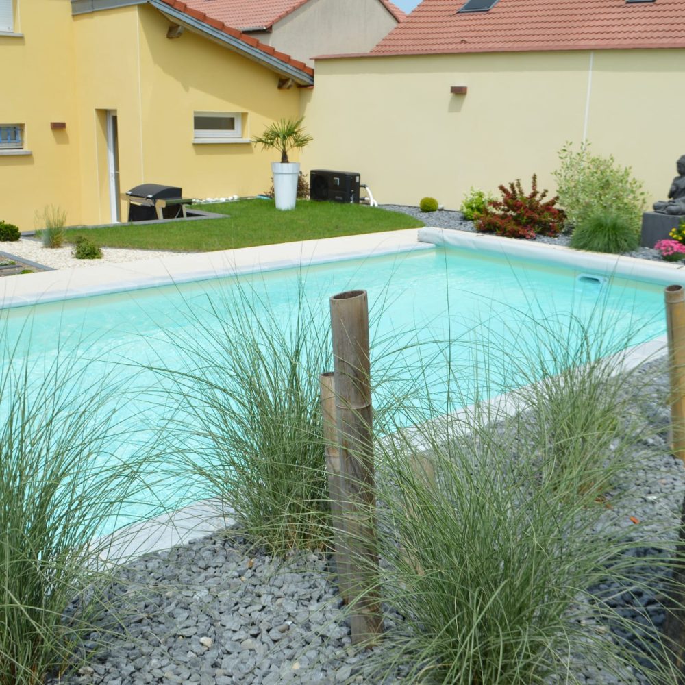 Piscine extérieure avec liner sable au coeur d'un jardin aménagé - Delalande Piscines & Spas
