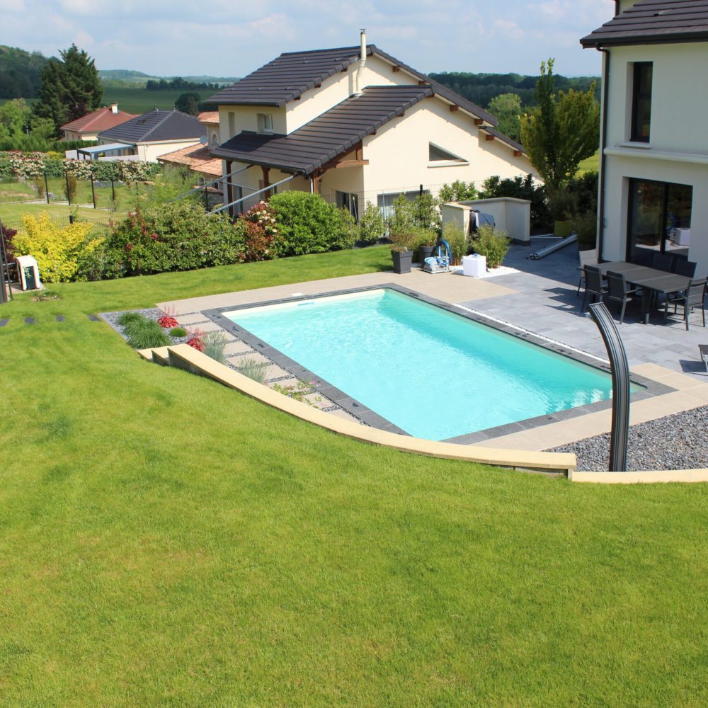 Piscine extérieure avec douche en continuité d'une terrasse en pierre naturelle - Delalande Piscines & Spas