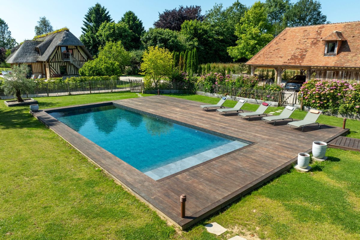 Piscine familiale de 13x5 avec un escalier toute largeur et margelles en bois - Réalisation Delalande Piscines & Spas