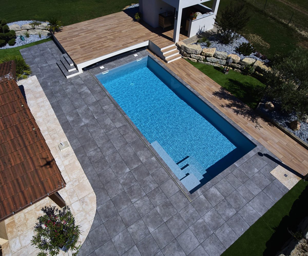 Piscine avec revêtement en membrane armée gris clair et escalier d’angle carré