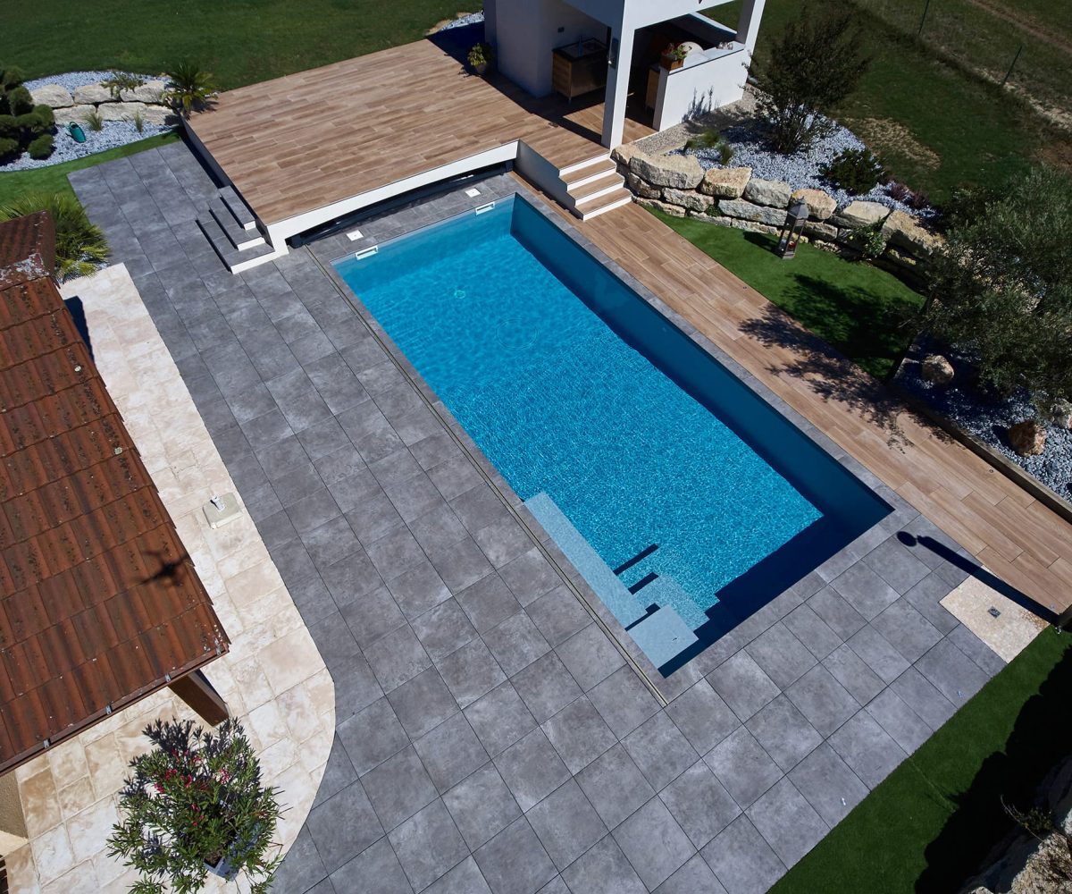 Piscine avec revêtement en membrane armée gris clair et escalier d’angle carré